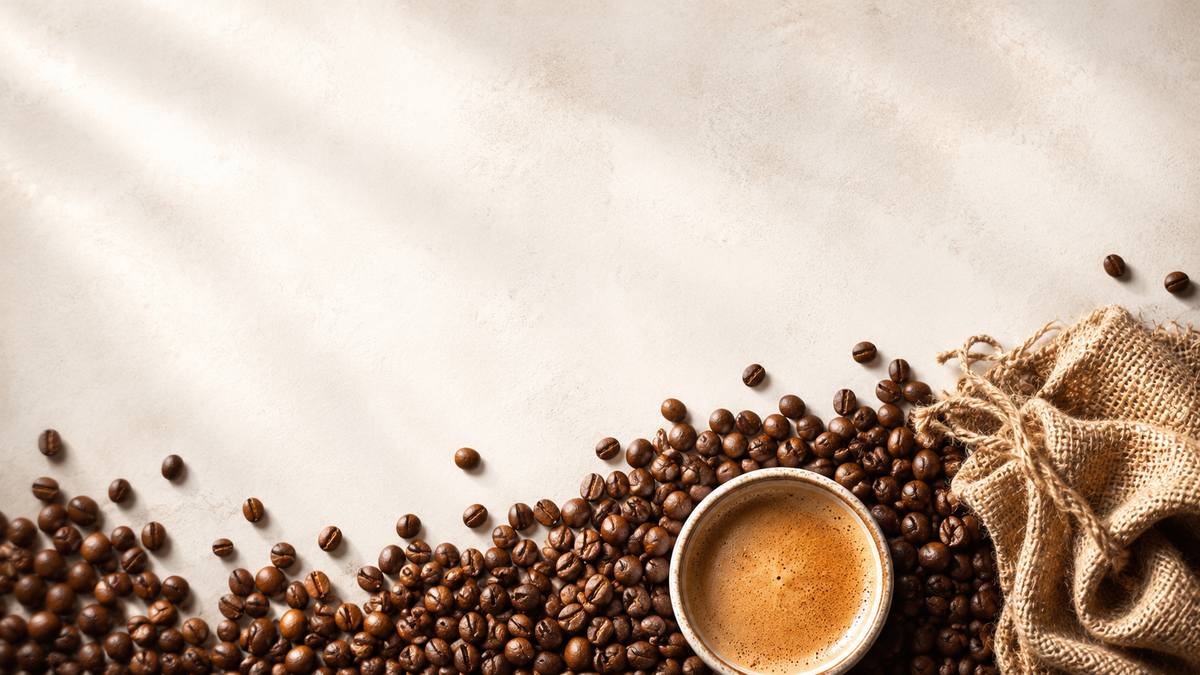 Ausgeschüttete Kaffeebohnen mit einer vollen Tasse Kaffee und einem Sack