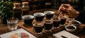Vier Gläser mit Kaffee und eine Hand mit einem Löffel, die ein Glas umrührt