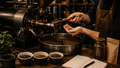 Person die an einen Kaffeeröster steht und geröstete Bohnen in der Hand hält